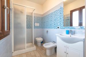 a bathroom with a toilet and a sink and a shower at La Finestra sul Mare in Isola Rossa +18 photos