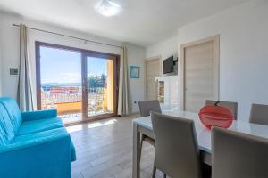 a living room with a table and a blue couch at La Finestra sul Mare in Isola Rossa