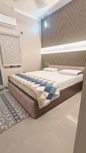 a bedroom with a large bed with a checkered blanket at ZM Homestay - Luxury Comfort Awaiting in Tājganj