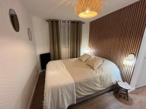 a small bedroom with a bed and a lamp at Le Verdun - Elegant fully-equipped one-bedroom in Bergerac +2 photos