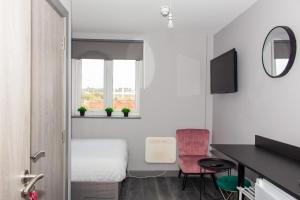 Kleines Zimmer mit einem Bett, einem Schreibtisch und einem Spiegel in der Unterkunft Mammut House in Liverpool