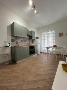 a kitchen with white cabinets and a table with chairs at Cuore di Agrigento Home in Agrigento