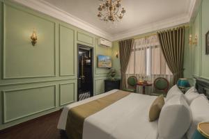 a bedroom with a large bed and a chandelier at Vina Vintage Hotel in Hue