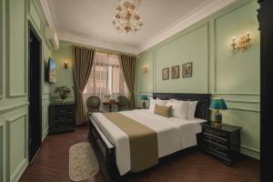 Un dormitorio con una cama grande y una lámpara de araña. en Vina Vintage Hotel, en Hue