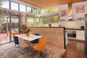 Una cocina con una mesa y sillas en una habitación. en La Boheme in the Treetops, en Margaret River Town 16 fotos más