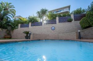 una gran piscina frente a una pared de ladrillo en Golf & Tides Deluxe, en Mossel Bay