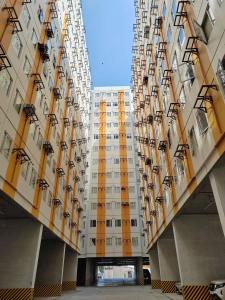 un edificio alto con giallo e bianco di Mountain City Condo Room for Rent in Quezon City a Manila