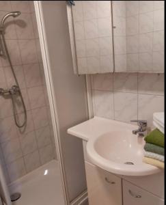 a white bathroom with a sink and a shower at Apartment Rossleithen 
