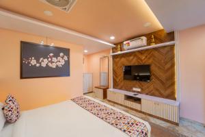 a hotel room with a bed and a flat screen tv at Bagicha villa and cottage in Mahabaleshwar