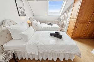 une chambre avec deux lits et une fenêtre dans l'établissement "Gelbe Koffer Vintage Maisonette" in Neunkirchen - 2 SZ - Self-Check-in - Parkplatz - Balkon - Badewanne - WLAN 250 Mbit - bis 4 Pers - zentrumsnah, à Neunkirchen