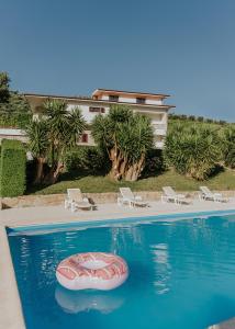 a swimming pool with a red raft in the water at Jerónimos Garden & Pool Villas in Lamego