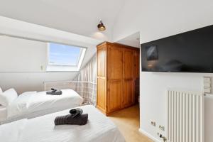 une chambre avec deux lits et une grande fenêtre dans l'établissement "Gelbe Koffer Vintage Maisonette" in Neunkirchen - 2 SZ - Self-Check-in - Parkplatz - Balkon - Badewanne - WLAN 250 Mbit - bis 4 Pers - zentrumsnah, à Neunkirchen 17 autres photos