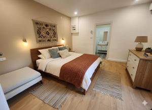 une chambre avec un grand lit et une commode dans l'établissement בית מקסים בלב העיר, à Tel Aviv