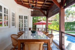 a dining room with a table and chairs and a pool at Palm Villa A Paradise for Families and Friends in Sanur in Sanur
