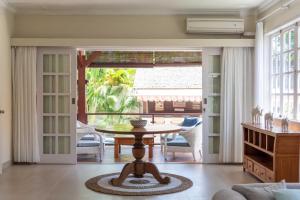 a living room with a table and a large window at Palm Villa A Paradise for Families and Friends in Sanur in Sanur