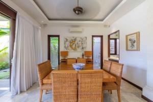 a dining room with a wooden table and chairs at Kejora Beachfront Estate Sanur -Stunning Villa Eleven in Sanur