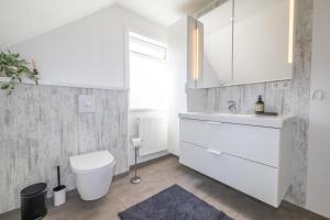a white bathroom with a toilet and a sink at Akureyri apartments in Akureyri +16 photos