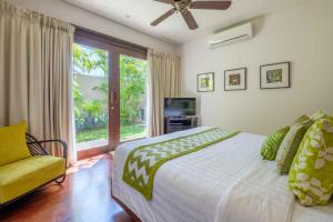 a bedroom with a large bed and a window at Kejora Beachfront Estate Sanur -Stunning Villa Eleven in Sanur