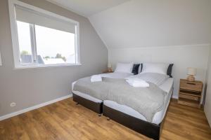 a bedroom with a bed and a window at LL Properties - Spacious Historic Home in Akureyri