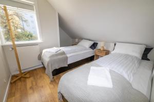 two beds in a small room with a window at LL Properties - Spacious Historic Home in Akureyri