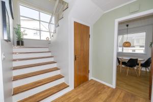 a staircase in a home with white walls and wood floors at LL Properties - Spacious Historic Home in Akureyri