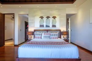 a bedroom with a large bed with umbrellas on the wall at Kejora Beachfront Estate Sanur -Stunning Villa Eleven in Sanur