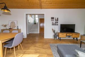 a living room with a dining table and a television at Akureyri apartments in Akureyri