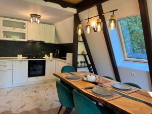 a kitchen with a wooden table and green chairs at Zago Alpin in Câmpulung Moldovenesc +11 photos