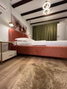 a bedroom with a large bed and a rug at Zago Alpin in Câmpulung Moldovenesc