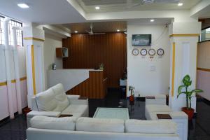a lobby with white couches in a room at Hotel Jetway Inn in Muthugadahalli +42 photos