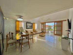 a dining room and living room with a table and chairs at Stylish La Romana Apartment with 2-Way Air Con Covered Parking in Batey Río Dulce +7 photos