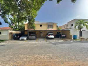 a building with cars parked in a parking lot at Stylish La Romana Apartment with 2-Way Air Con Covered Parking in Batey Río Dulce