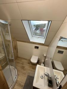 a bathroom with a sink and a toilet and a window at Gorczańskie Domki in Ochotnica Górna +33 photos