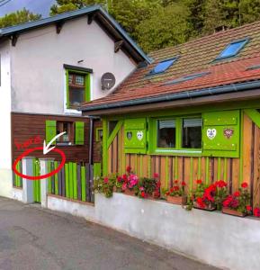a house with a red arrow painted on it at Gites Les Lupins avec Sauna et petit déjeuner inclus 2 personnes in Geishouse