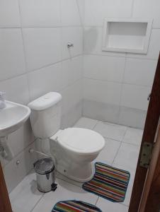 Un baño blanco con inodoro y lavabo. en Casa aconchegante, en Belém