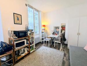 un salon avec une télévision et une table dans l'établissement Appart calme et confortable Père Lachaise, à Paris