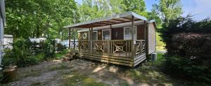 a small wooden cabin in a yard with trees at Le charme des Landes in Aureilhan