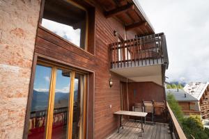 a balcony of a house with a bench on it at Apartment Mélodie de Rêve in Crans-Montana