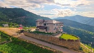 a house sitting on top of a stone wall at SaffronStays Ridgeview Manor, Mukteshwar - 3BHK Villa with Himalayan Views & Verandahs in Mukteshwar