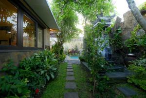 a garden with a pathway next to a house at Villa Nesanur - Comfortable & Spacious Beachside Sanur in Sanur +25 photos