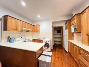 a kitchen with wooden cabinets and a counter top at Twin Room Ideal for Friends and Travelers - R5 in Sydney