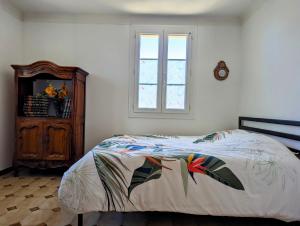 a bedroom with a bed and a dresser and a window at Gîte de campagne - 1 chambre double in Caumont-sur-Durance