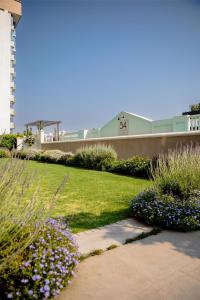 a garden with flowers and a sidewalk in front of a building at 54 on Bath, Johannesburg Rosebank in Johannesburg