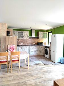 Una cocina con una mesa y un refrigerador blanco. en Schöne Wohnung 12E Wildpark Mainz, en Niederdorla