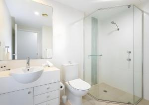 Un baño con inodoro y ducha de cristal. en Pacific Blue Poolside Escape, en Salamander Bay 4 fotos más