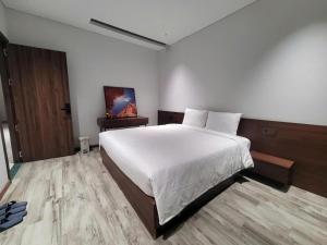 a bedroom with a large white bed and a wooden floor at Toàn Cầu Villa in Dương Cảnh