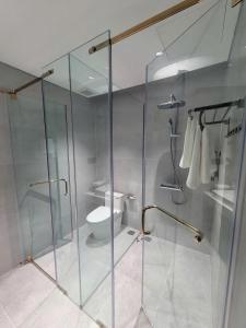 a bathroom with a glass shower and a toilet at Toàn Cầu Villa in Dương Cảnh