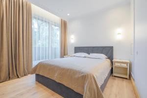 Ένα ή περισσότερα κρεβάτια σε δωμάτιο στο Simpsono Apartamentai