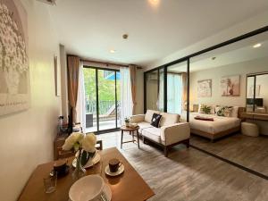 una sala de estar con un sofá y una mesa en The Deck Patong Phuket by Mickey, en Patong Beach