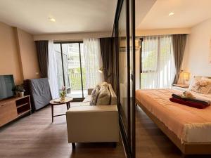 Un dormitorio con una cama grande y un televisor. en The Deck Patong Phuket by Mickey, en Patong Beach